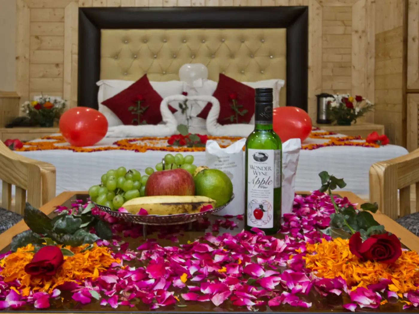 Romantic honeymoon suite with rose petals, fruit, and wine for a mountain getaway.