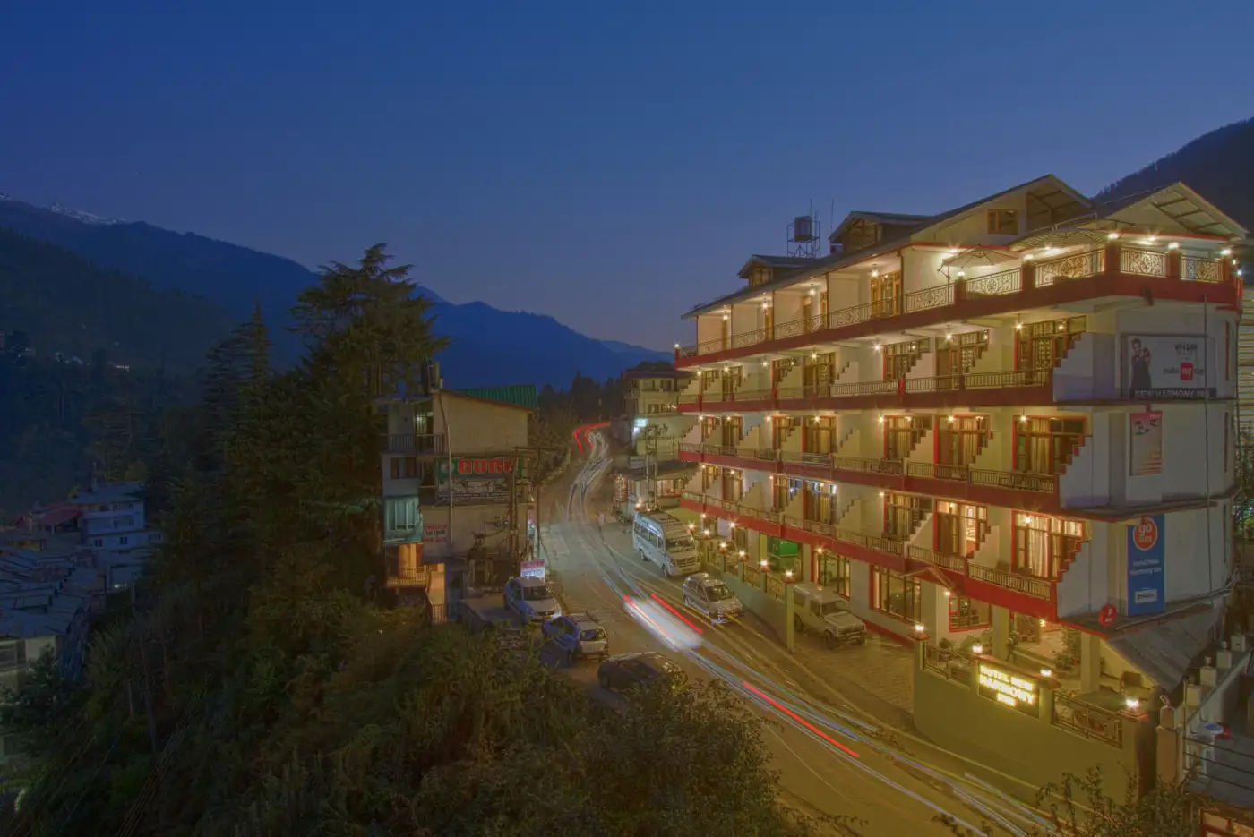  Hotel exterior at night with balconies and warm lighting. 