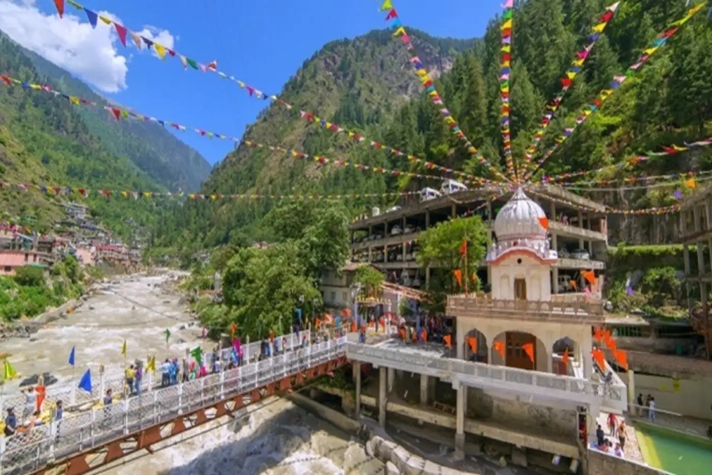 Parvati River and temple in Kasol, India, decorated with colorful flags